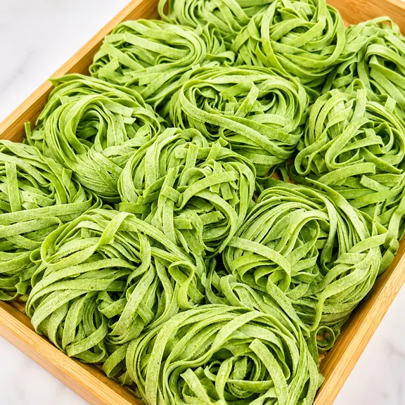 Fresh handmade spinach fettuccine pasta nests prepared daily