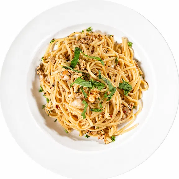 Garlic butter spaghetti topped with herbs and grated Parmesan cheese